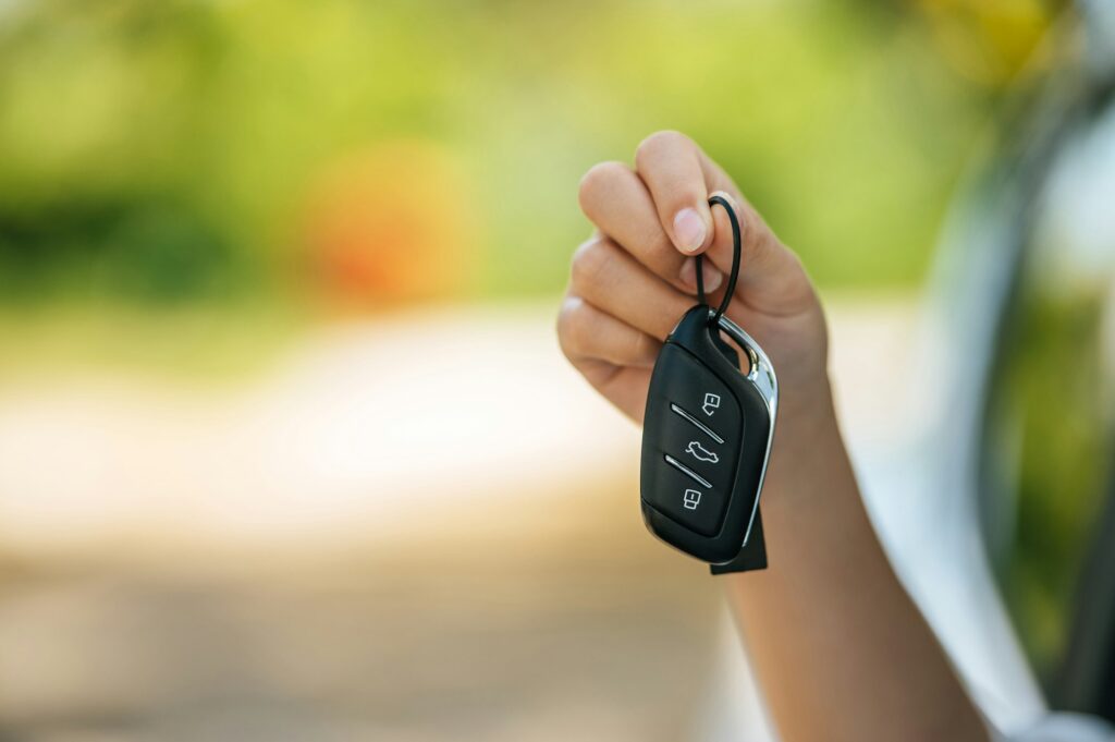 girl sitting in the car and holding the car keys